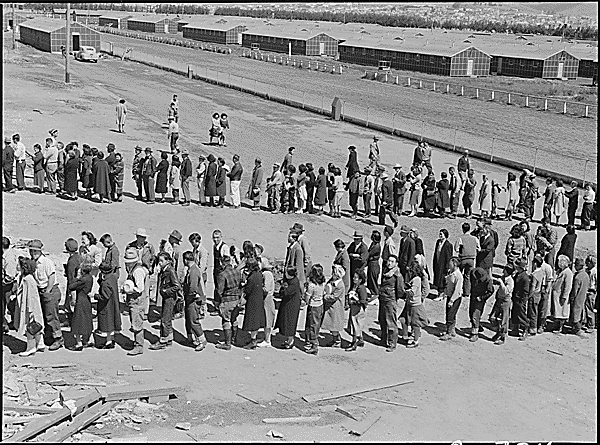 Dorothea_Lange_-_American_internees_in_mess_hall_line_at_Tanforan_Assembly_Center_San_Bruno_CA_April_29_1942.gif