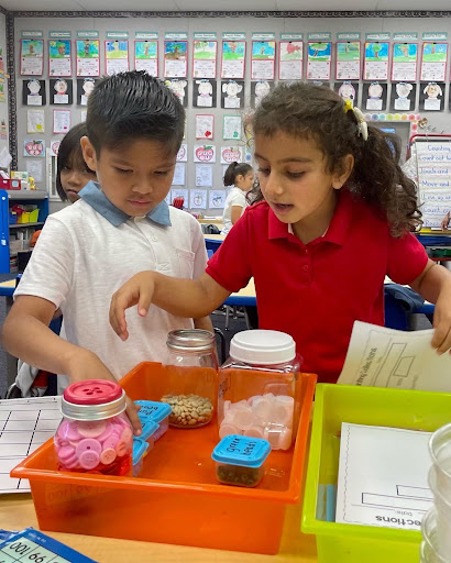 Children looking at jars in a container