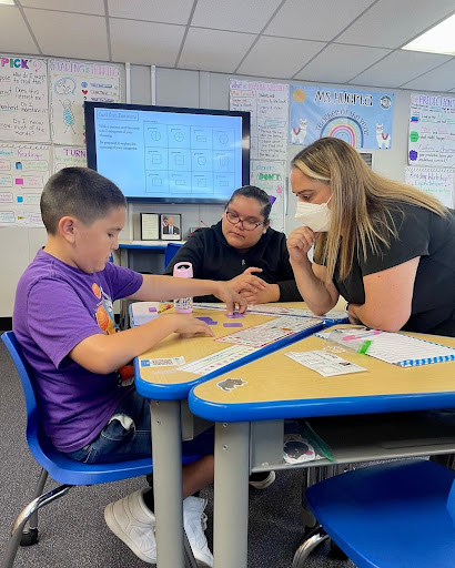 Student with teachers at a desk